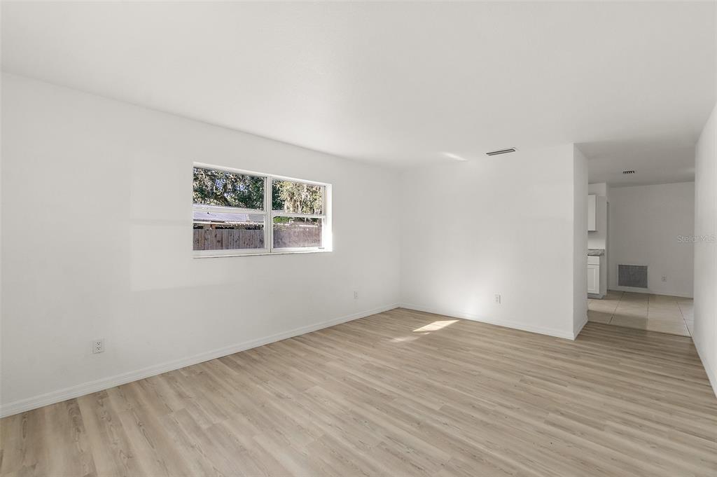 145 Oak Ridge Avenue Edgewater, FL 32132 - Photo 11 of 32 an empty room with wooden floor and windows