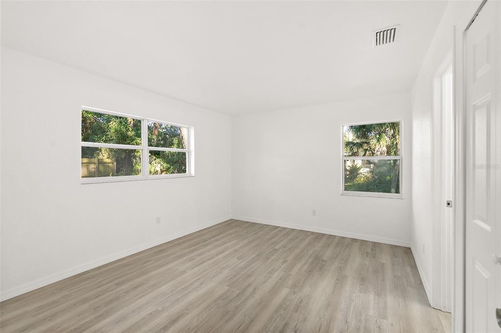 145 Oak Ridge Avenue Edgewater, FL 32132 - Photo 12 of 32 an empty room with wooden floor and window