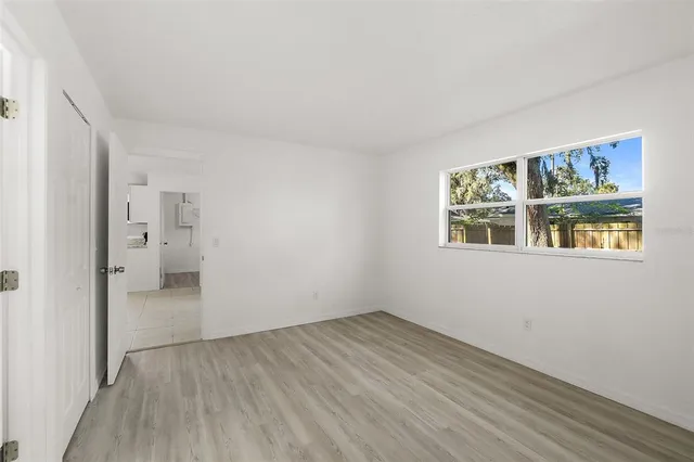 a view of empty room with wooden floor and windows