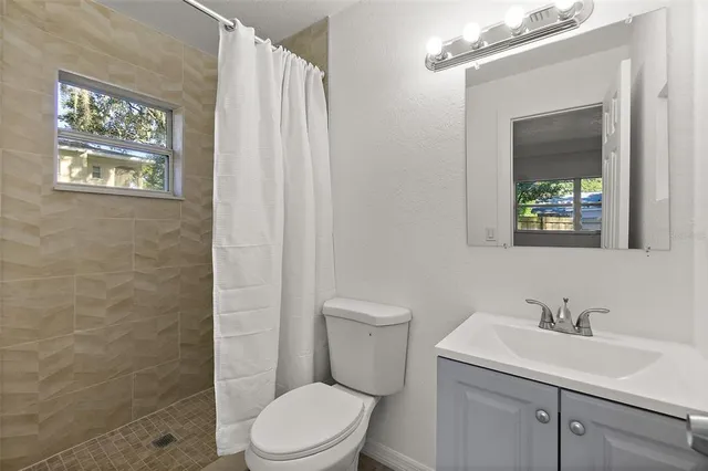 a bathroom with a toilet sink vanity and mirror