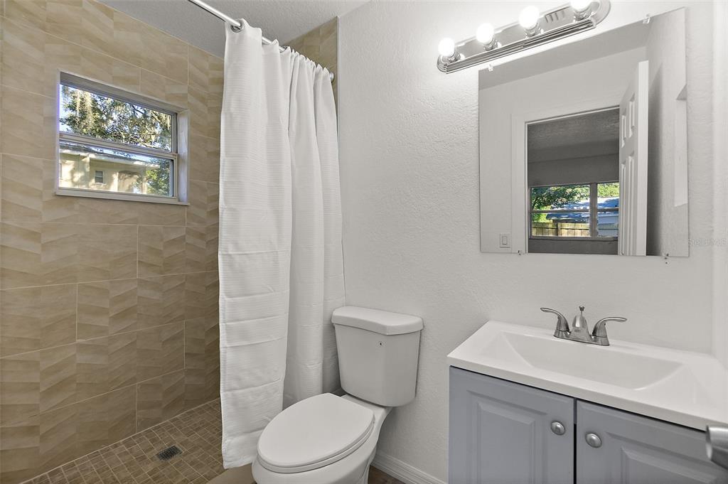 145 Oak Ridge Avenue Edgewater, FL 32132 - Photo 15 of 32 a bathroom with a toilet sink vanity and mirror
