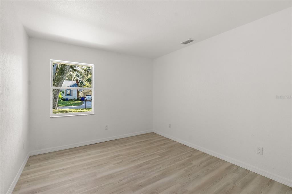 145 Oak Ridge Avenue Edgewater, FL 32132 - Photo 16 of 32 wooden floor in an empty room with a window