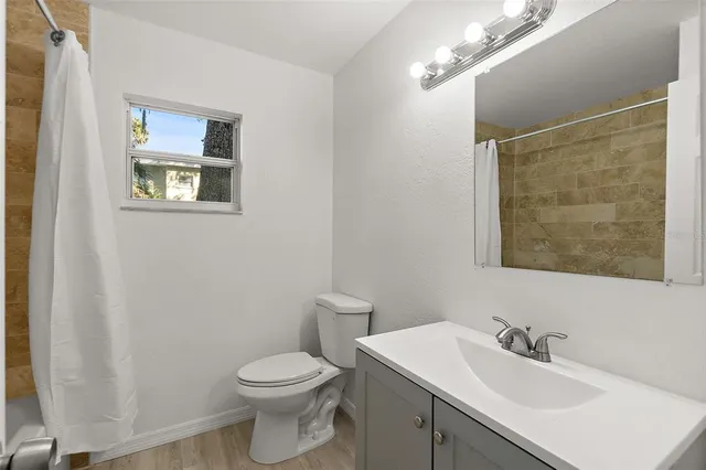 a bathroom with a toilet a sink and mirror
