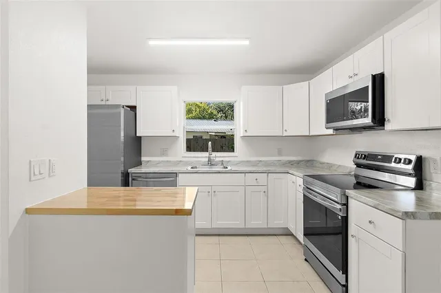 a kitchen with stainless steel appliances granite countertop a stove microwave and sink