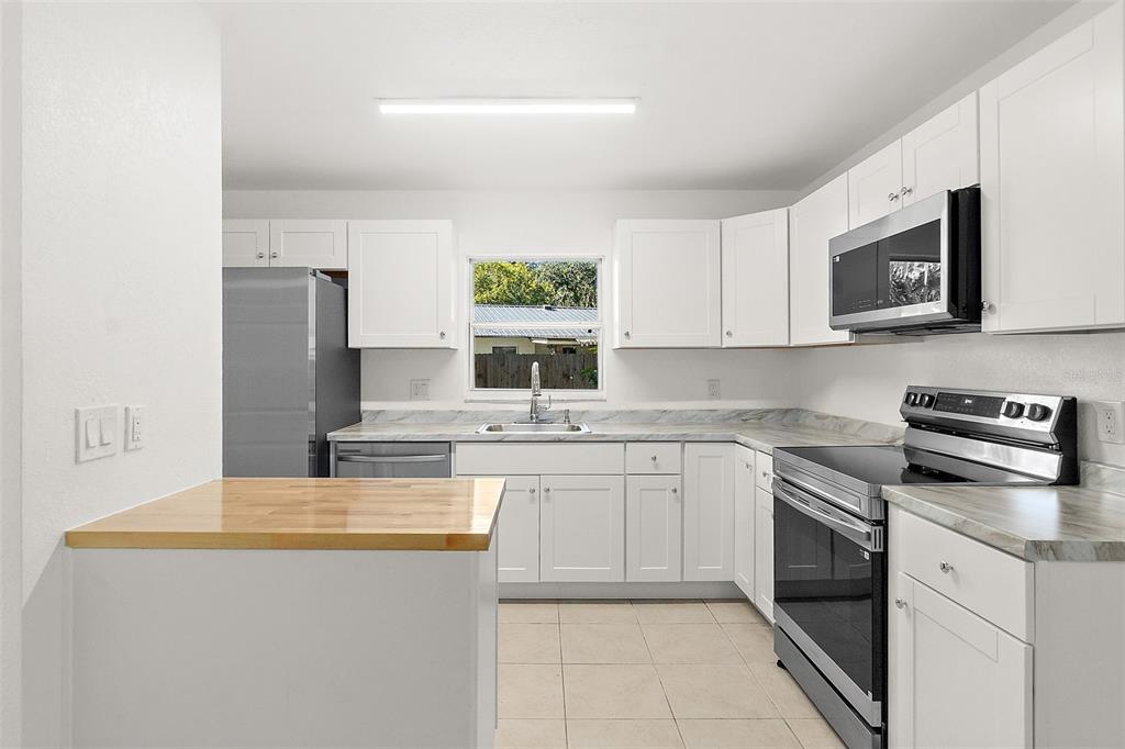 145 Oak Ridge Avenue Edgewater, FL 32132 - Photo 2 of 32 a kitchen with stainless steel appliances granite countertop a stove microwave and sink