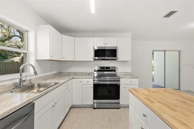 a kitchen with stainless steel appliances granite countertop a sink and stove top oven