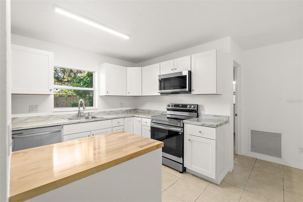 145 Oak Ridge Avenue Edgewater, FL 32132 - Photo 4 of 32 a kitchen with a sink stove and microwave