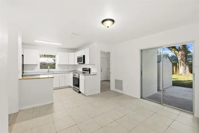 a kitchen with white cabinets and window