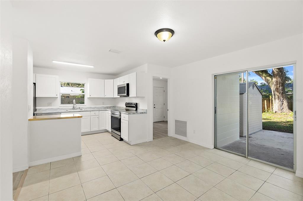 145 Oak Ridge Avenue Edgewater, FL 32132 - Photo 5 of 32 a kitchen with white cabinets and window