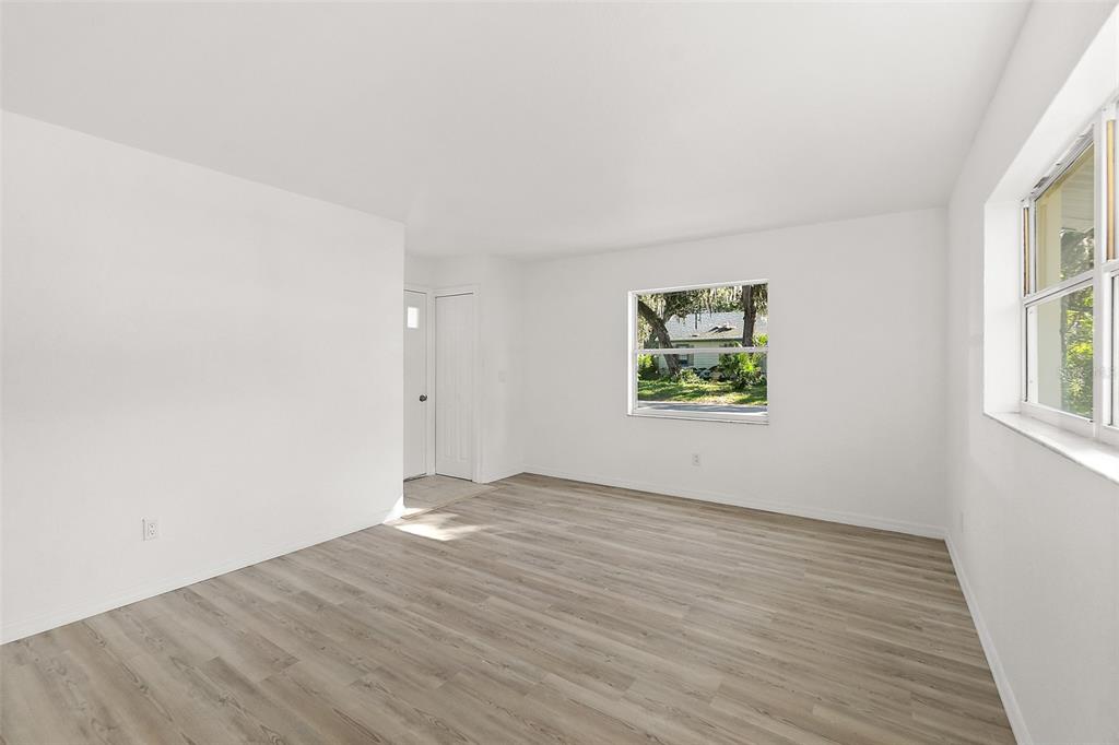 145 Oak Ridge Avenue Edgewater, FL 32132 - Photo 10 of 32 an empty room with wooden floor and windows