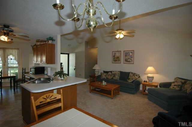 2105 Bufflehead Road Raleigh, NC 27616 - Photo 10 of 12 a living room with furniture a chandelier and a table