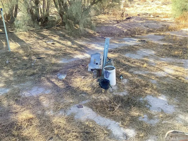 a view of a dry yard with wooden fence