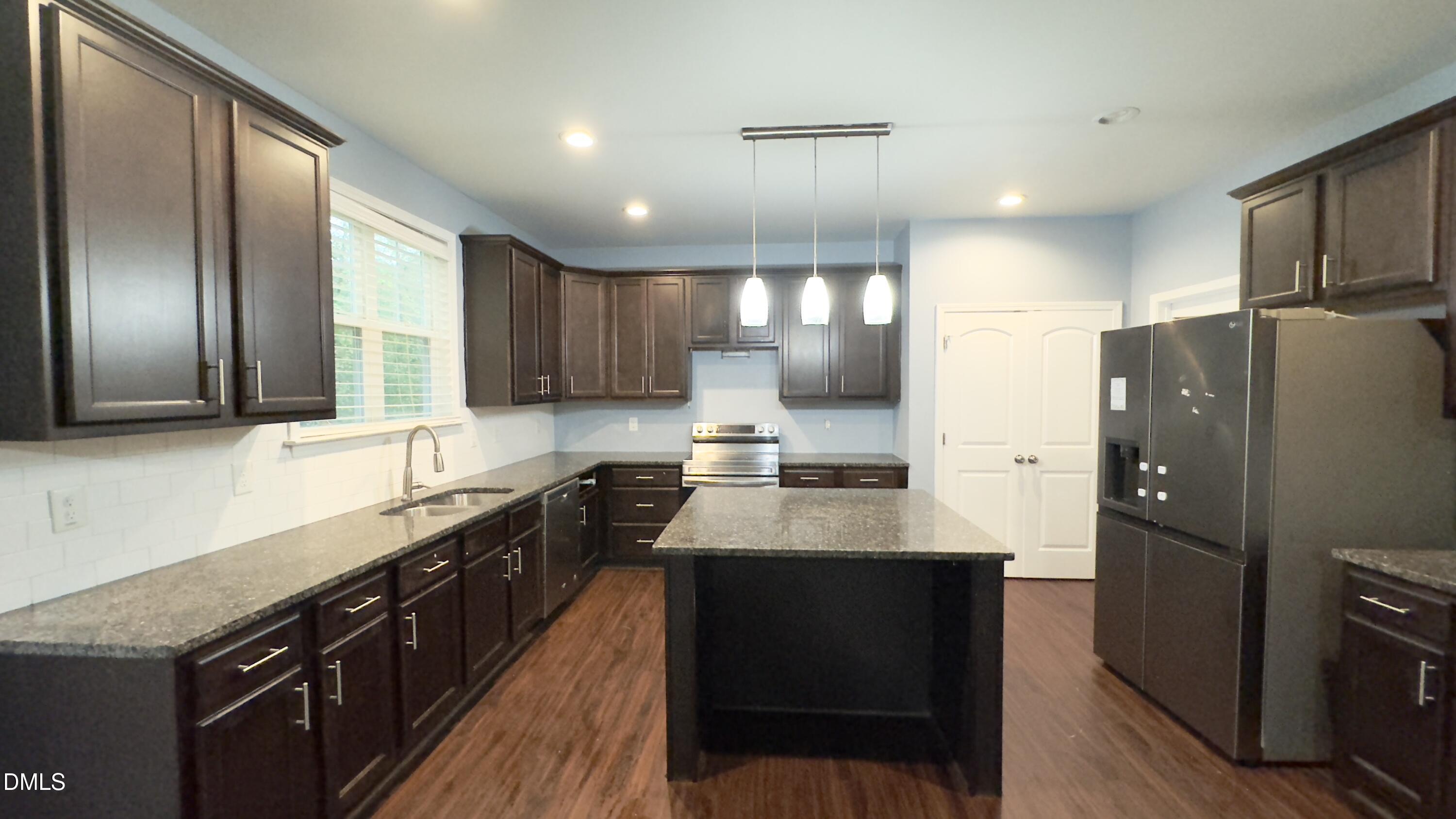 5401 Razan Street Raleigh, NC 27616 - Photo 6 of 30 a kitchen with granite countertop stainless steel appliances and wooden cabinets
