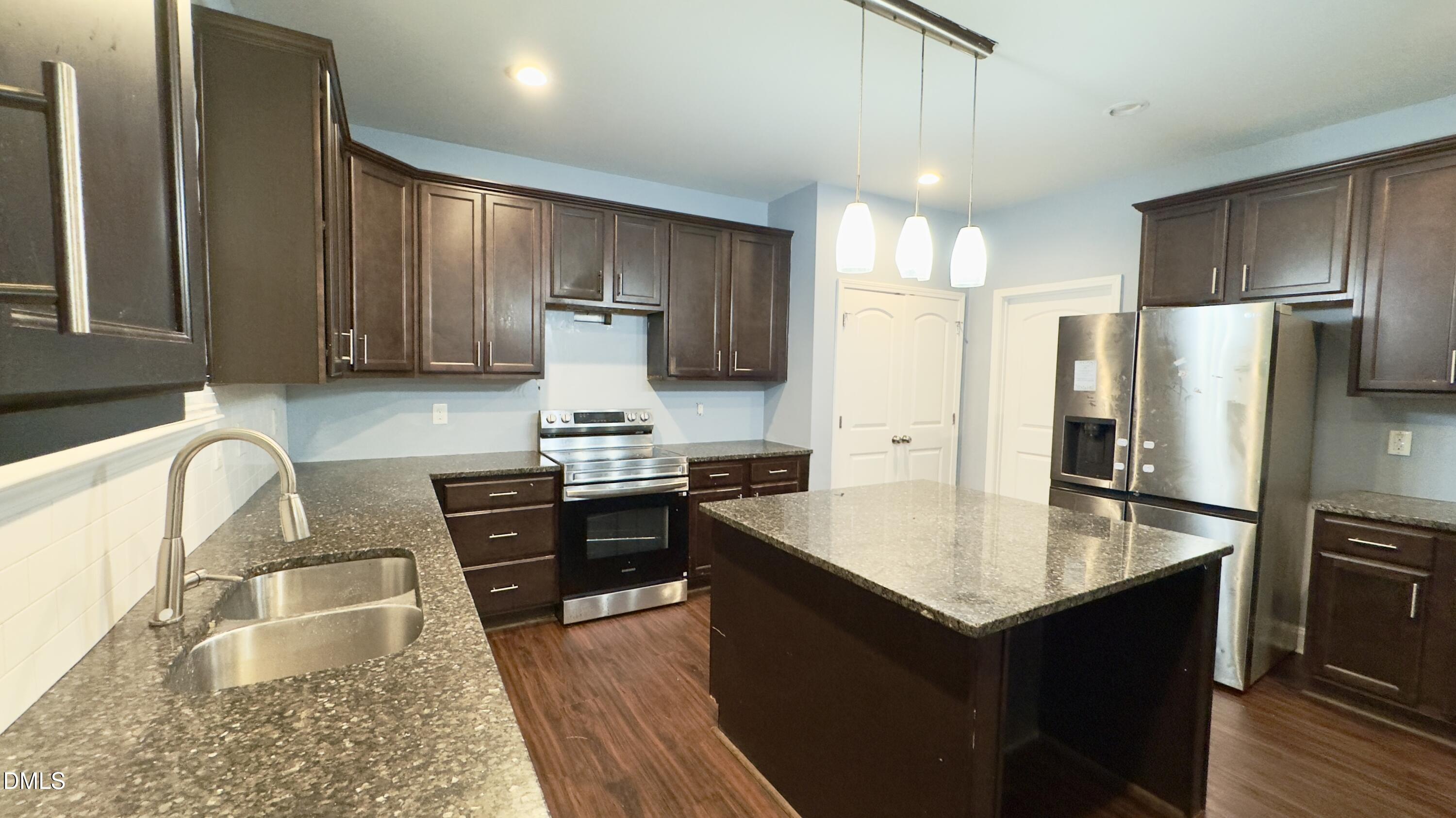 5401 Razan Street Raleigh, NC 27616 - Photo 7 of 30 a kitchen with stainless steel appliances granite countertop a refrigerator stove microwave and sink