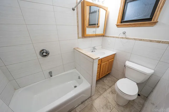 a white toilet and tub sitting next to a bathroom sink