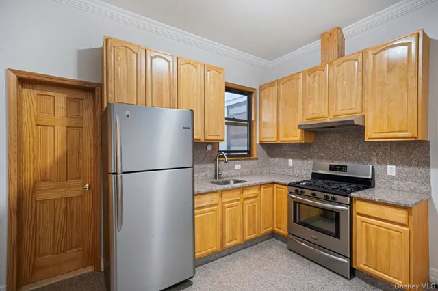 a kitchen with a refrigerator sink and cabinets