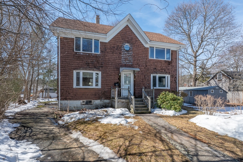 a front view of a house with a yard covered in snow