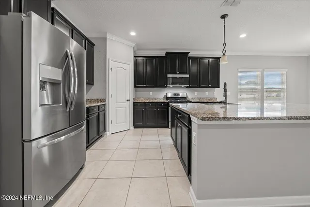 a kitchen with stainless steel appliances granite countertop a refrigerator a sink a stove and oven