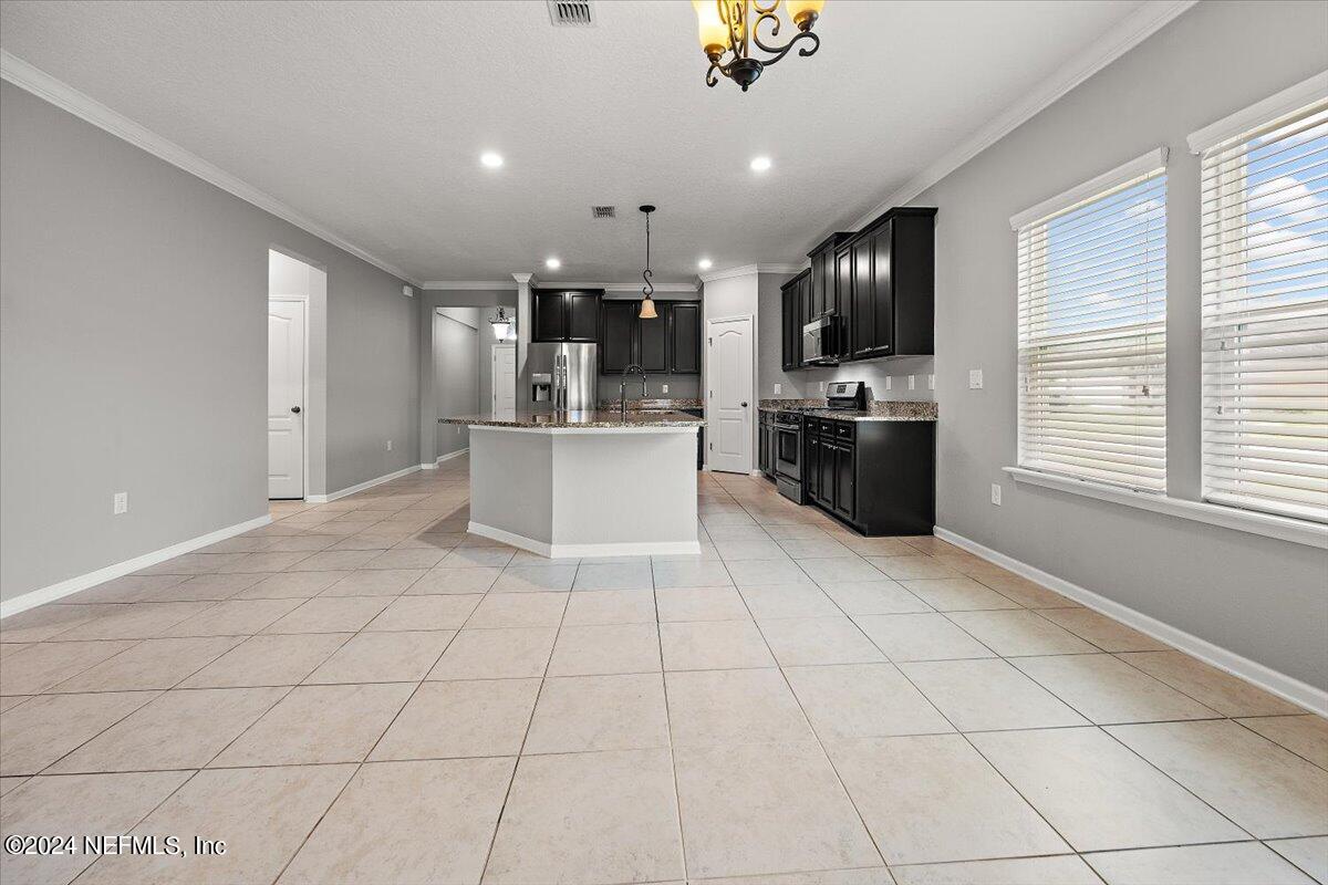 13 Pantano Vista Way St. Augustine, FL 32095 - Photo 10 of 25 a kitchen with stainless steel appliances kitchen island granite countertop a refrigerator and a sink