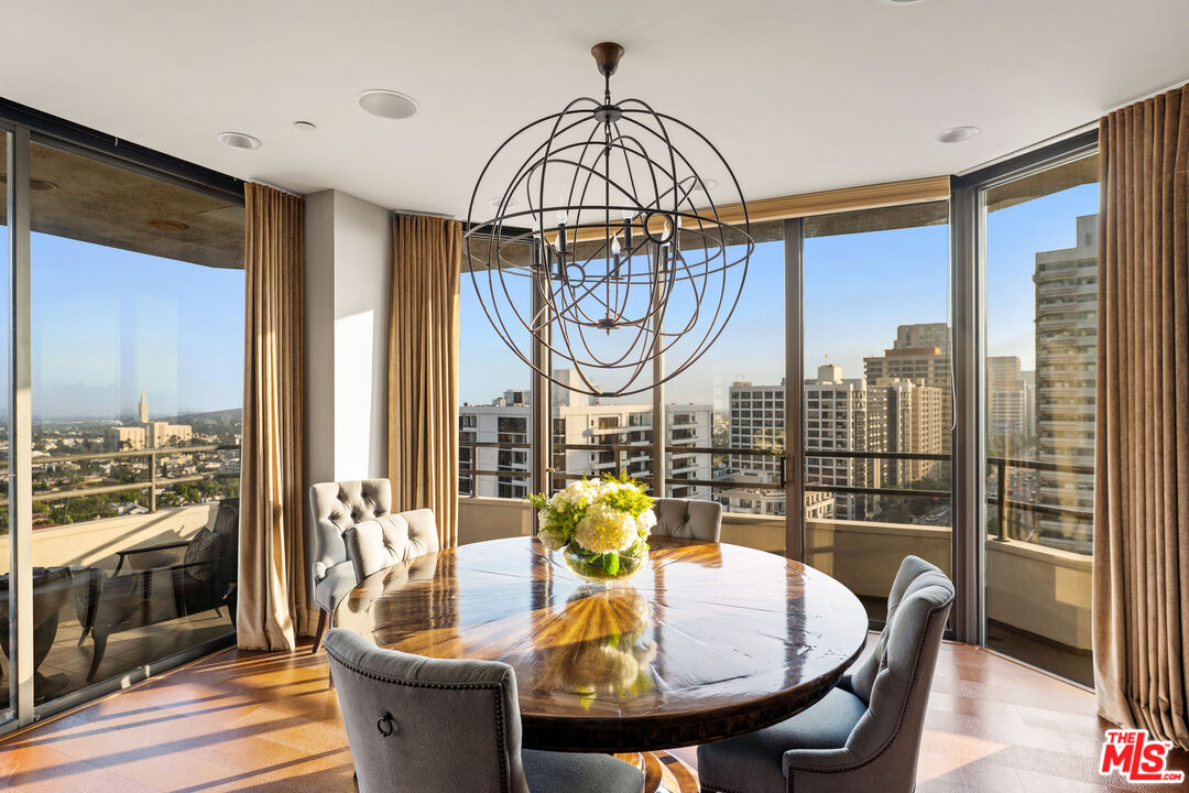 a dining room with furniture a chandelier and wooden floor