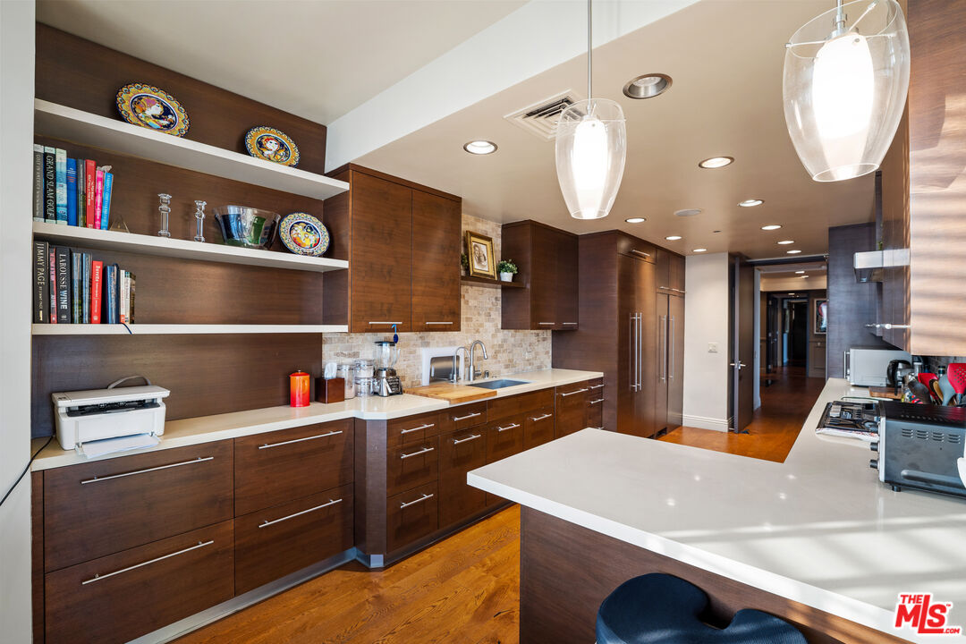 10601 Wilshire Boulevard, Unit 1603 Los Angeles, CA 90024 - Photo 12 of 33 a kitchen with a sink dishwasher and a stove with wooden floor