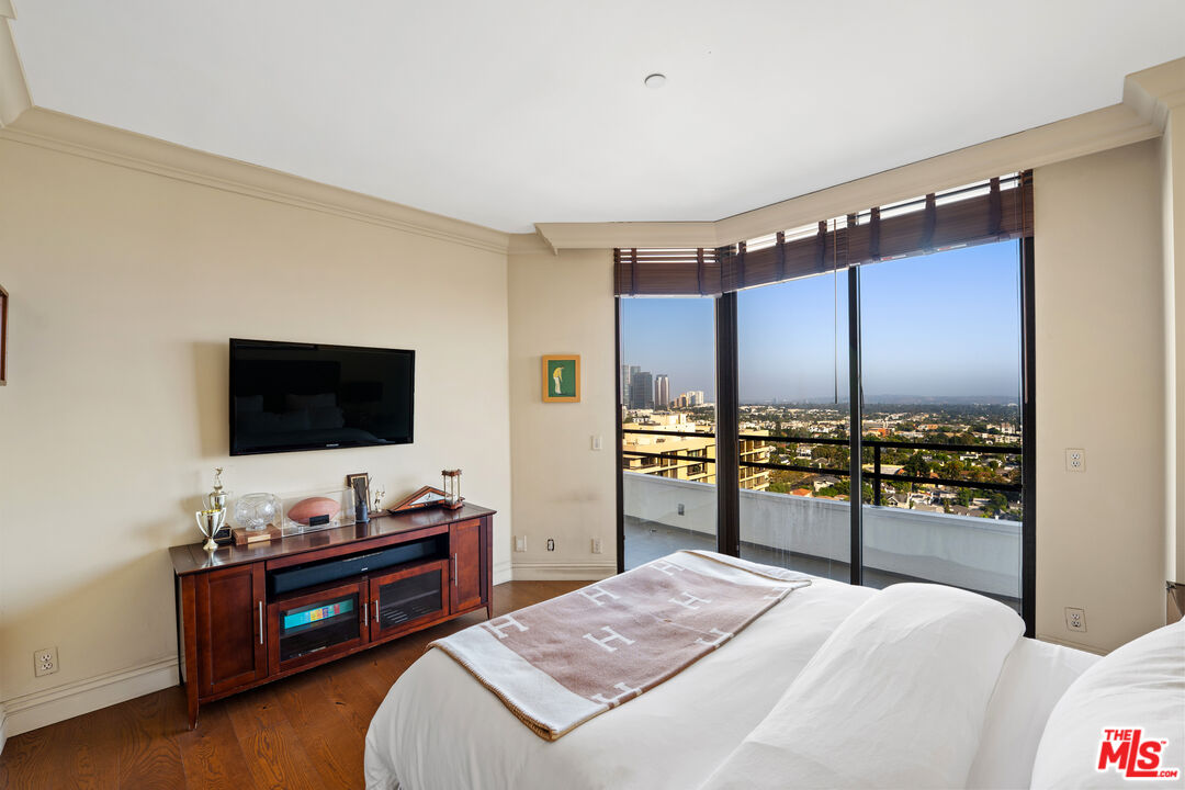 10601 Wilshire Boulevard, Unit 1603 Los Angeles, CA 90024 - Photo 21 of 33 a bedroom with a bed and a flat screen tv