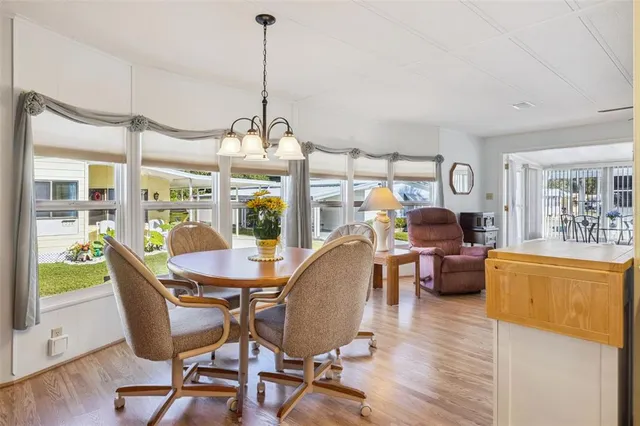 a dining room with furniture a chandelier and wooden floor