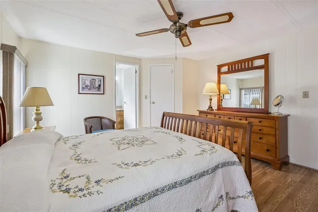 a bedroom with a bed a dresser and painting on the wall