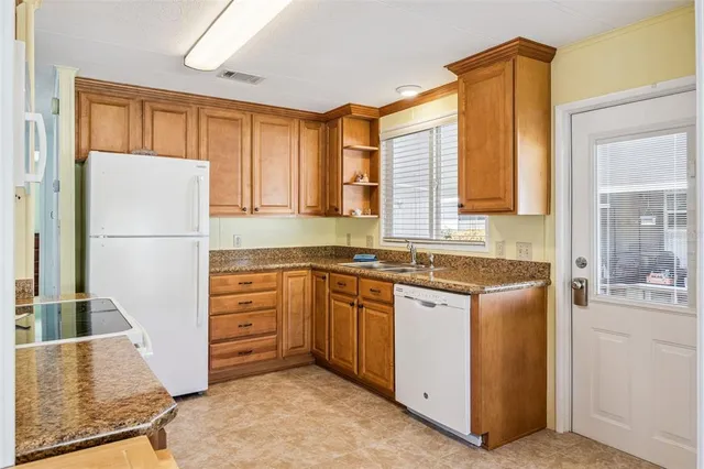 a kitchen with stainless steel appliances granite countertop a refrigerator and a stove