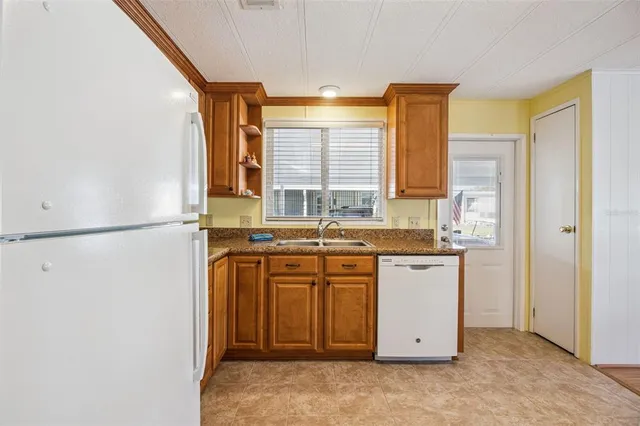 a kitchen with stainless steel appliances granite countertop a sink and a refrigerator