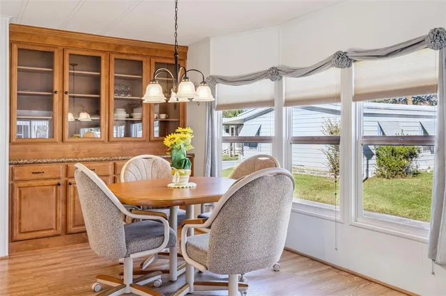 a dining room with furniture a chandelier and wooden floor