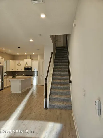 a open kitchen with white cabinets and stainless steel appliances