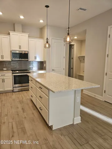 a large kitchen with kitchen island a sink stainless steel appliances and cabinets