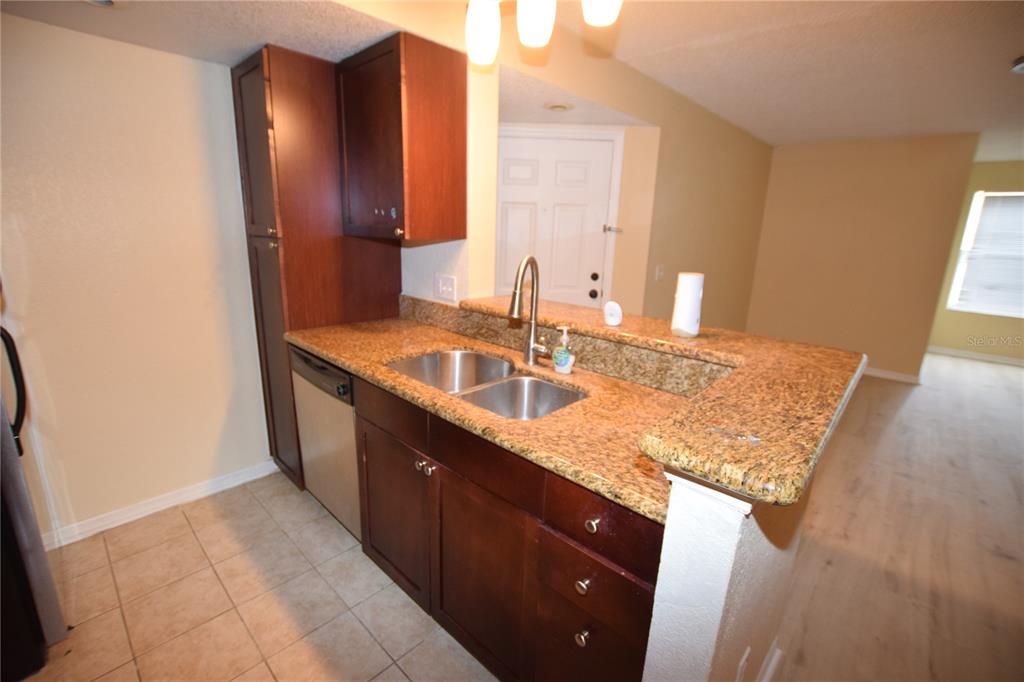 5120 Conroy Road, Unit 511 Orlando, FL 32811 - Photo 11 of 32 a bathroom with a granite countertop sink and a mirror