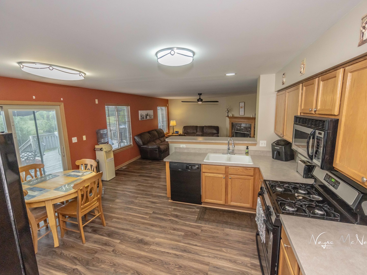 27055 West Sycamore Road Channahon, IL 60410 - Photo 12 of 31 a kitchen with a stove a sink dishwasher a refrigerator and a dining table with wooden floor