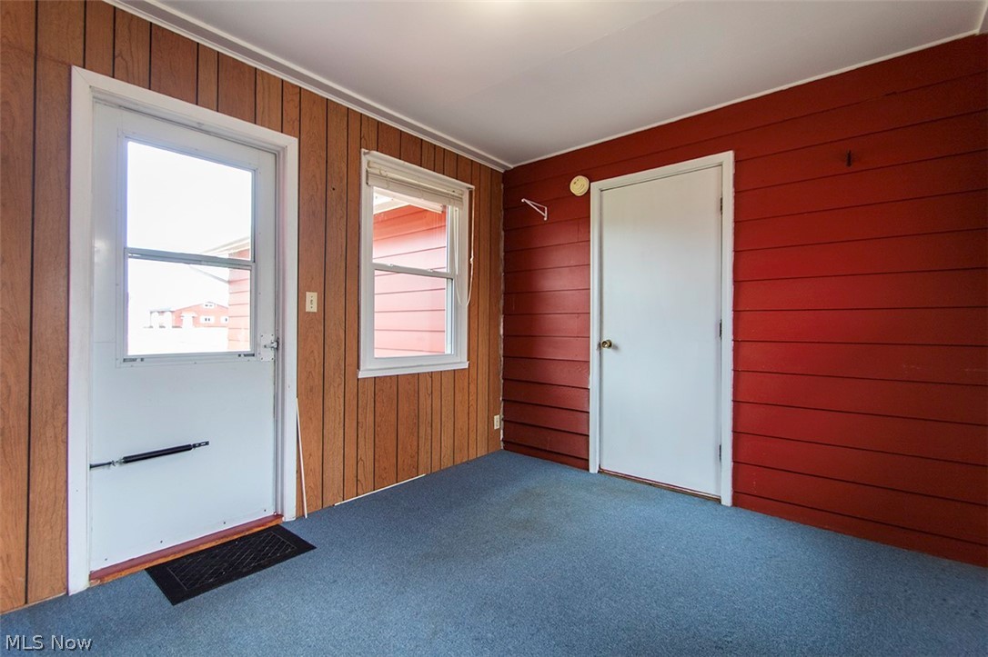 6961 Bear Swamp Road Medina, OH 44256 - Photo 24 of 40 Doorway to outside featuring carpet and wooden walls