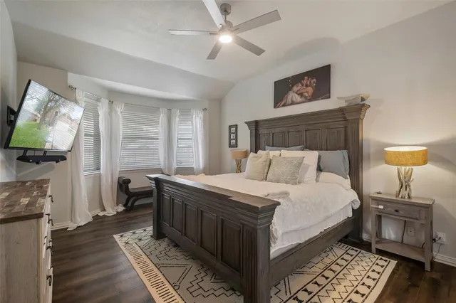 a bedroom with a bed and a flat tv screen on dresser