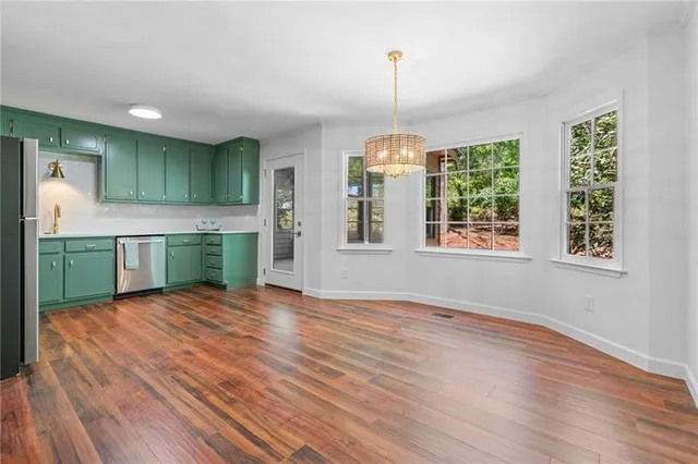 a view of empty room with window and wooden floor