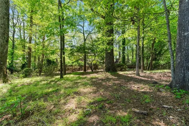 an aerial view of residential house with outdoor space and trees all around