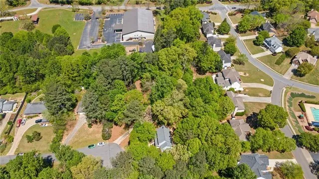 an aerial view of residential house with outdoor space and trees all around
