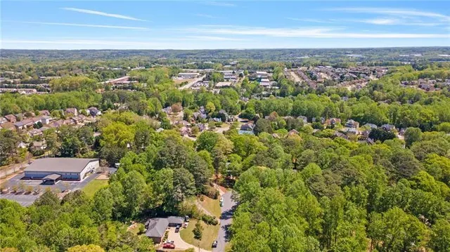 an aerial view of residential house with outdoor space and trees all around