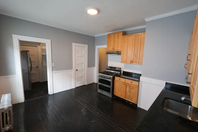 a kitchen with wooden floor and black appliances