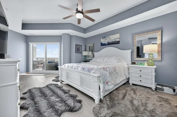 a bedroom with a large bed and a chandelier fan