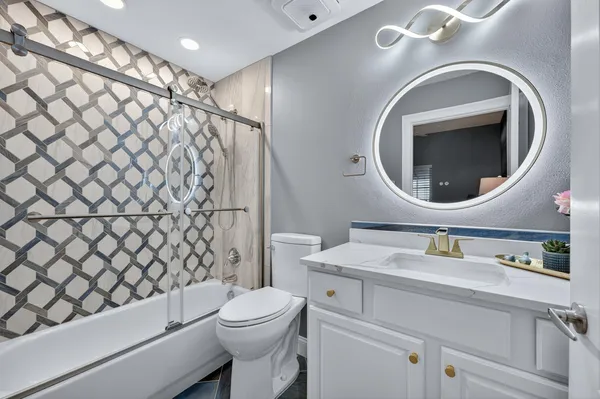 a bathroom with a sink mirror vanity and toilet