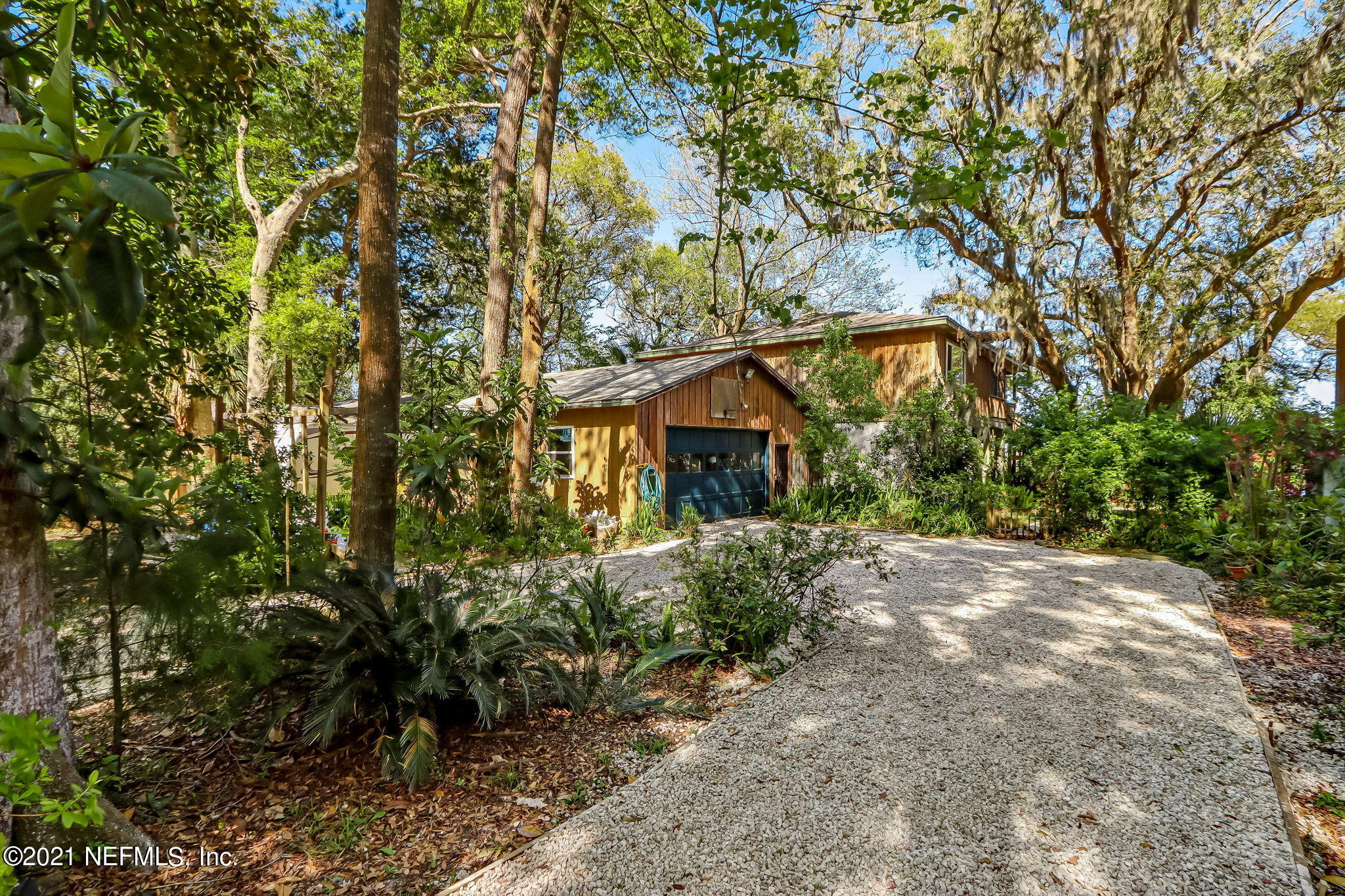 97110 Pirates Point Road Yulee, FL 32097 - Photo 2 of 34 a backyard of a house with plants and large trees