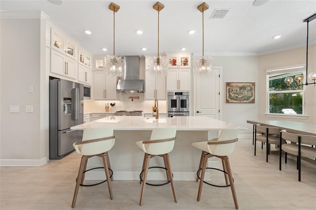 10175 Brocksport Circle Gotha, FL 34734 - Photo 9 of 54 a kitchen island with stainless steel appliances kitchen island granite countertop a dining table chairs and sink