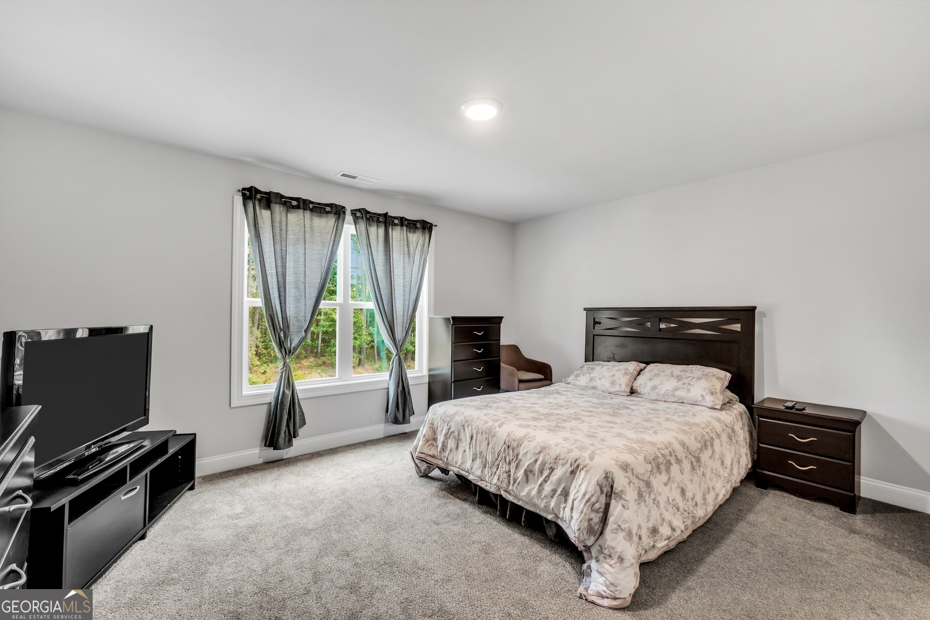 800 Rock House Road Senoia, GA 30276 - Photo 13 of 23 a bedroom with a bed and a flat tv screen on a dresser