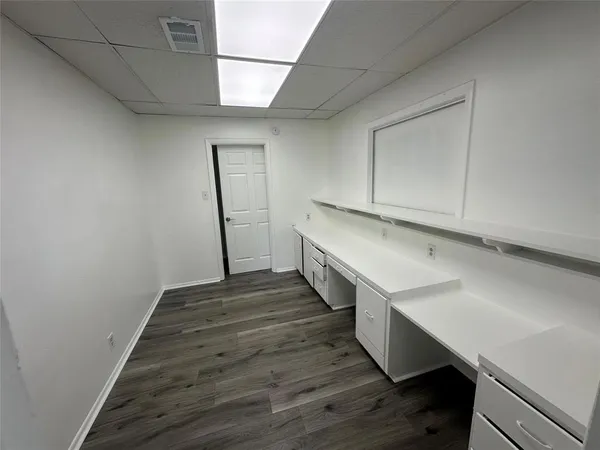 a room with wooden floor and white walls