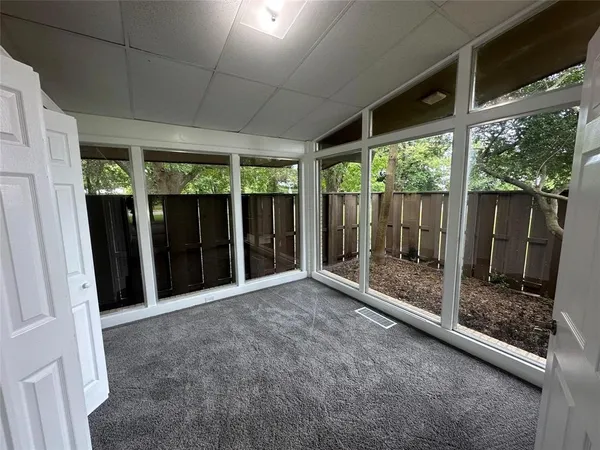 a view of backyard with large window and front door
