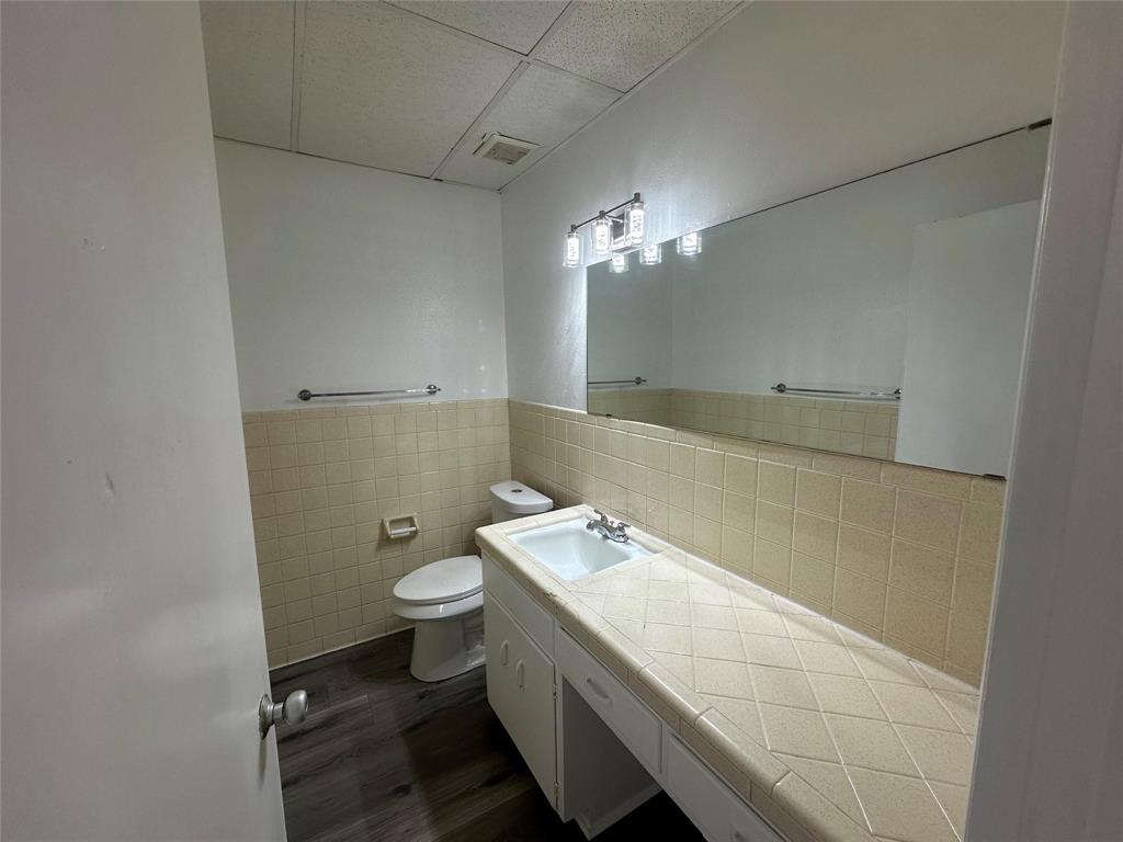 4723 North Loy Lake Road Sherman, TX 75092 - Photo 10 of 16 a bathroom with a granite countertop sink a toilet and a mirror